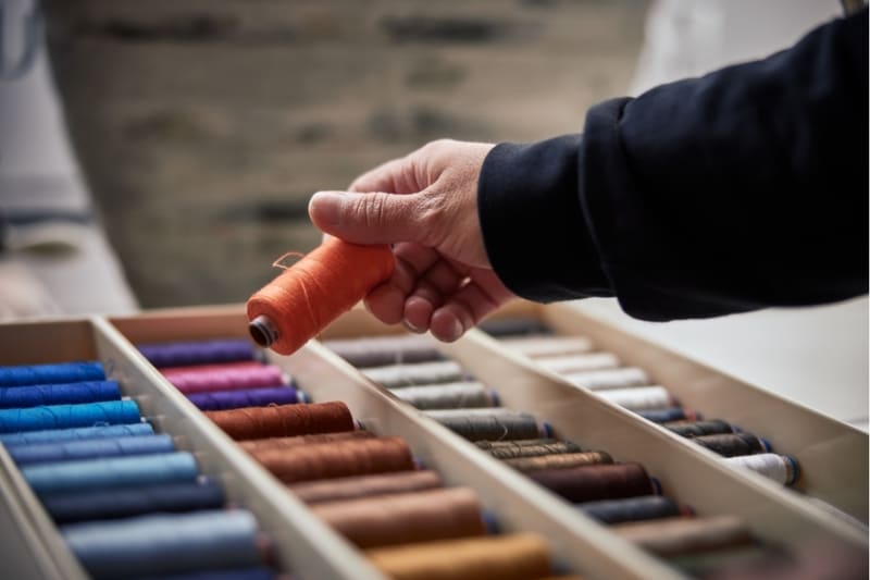 Kleermaker bezig met naaiwerk